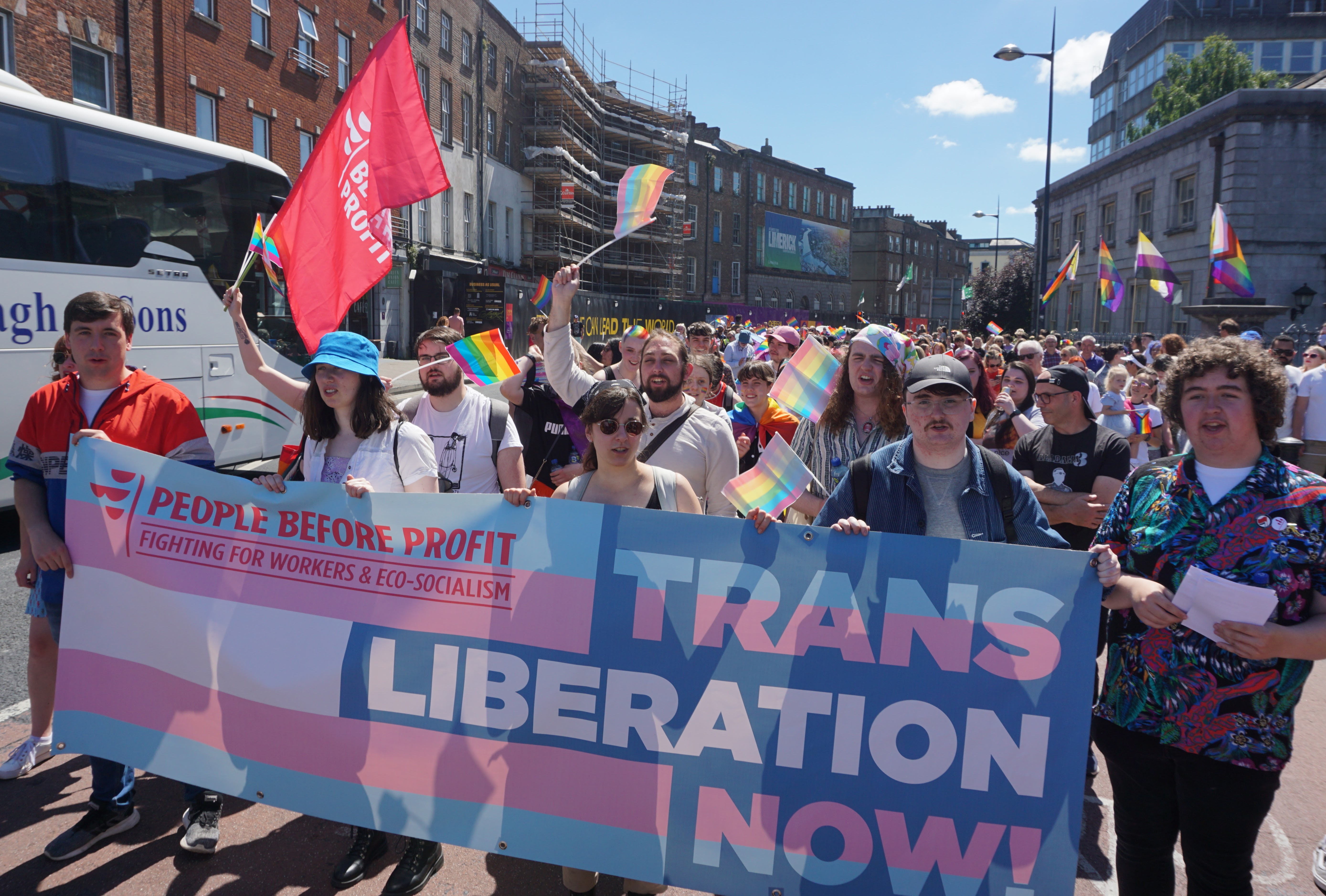 Members of People Before Profit marching in the Limerick Pride parade behind a banner with the words "Trans Liberation Now"